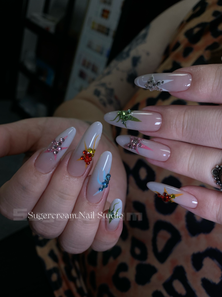 Colourful floral nail art on long, natural-looking acrylic nails.