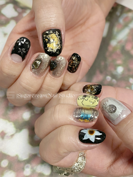 Colourful nail art design featuring various patterns and characters on different nails.