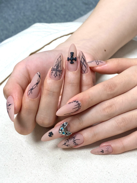 Nail art featuring intricate designs, symbols, and pastel colours on long nails.
