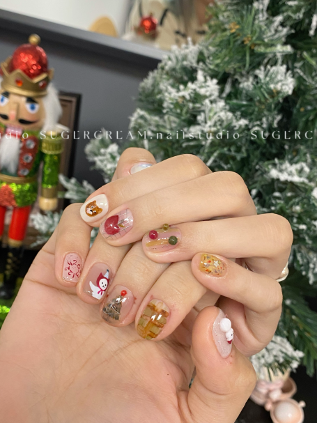 Festively decorated holiday nails with variousChristmas-themed designs.