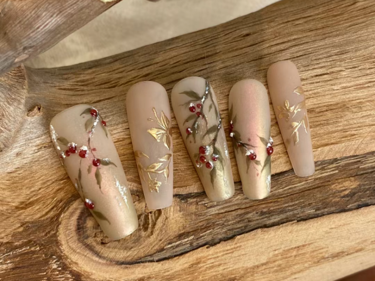 Nail designs featuring floral and berry patterns on a neutral background.