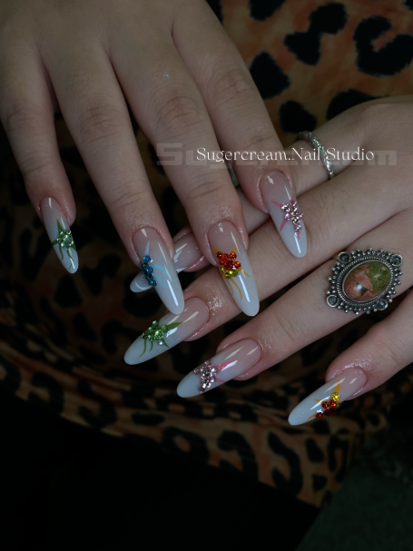Decoratively painted long nails with floral and themed designs, adorned with a ring.